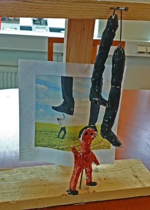 Foto på staty av en liten person som blir trampad på. I bakgrunden sitter även ett foto som illustrerar detta. Foto på staty av en liten person som blir trampad på. I bakgrunden sitter även ett foto som illustrerar detta.