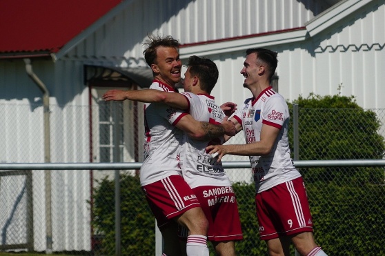Oskar Törnfeldt (i mitten) är glödhet just nu och kramas här om av sina lagkamrater i matchen mot Åsa. Foto: IS Halmia