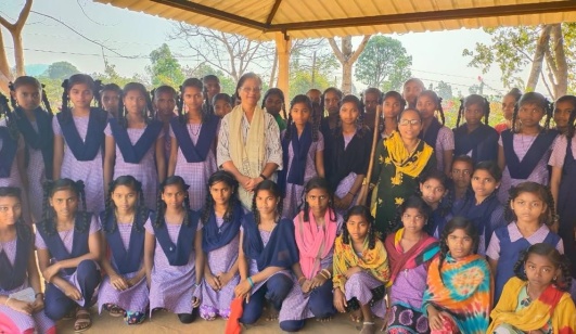 Maya (i ljus klädsel) tillsammans med elever på en av skolorna i Dharampur.