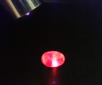 Då en blå safir belyses med blå laser (405nm) förväntas inte att den ska visa röd färg om den är naturlig och obehandlad, istället brukar den reaktionen vara en tydlig indikation på att stenen är beha Då en blå safir belyses med blå laser (405nm) förväntas inte att den ska visa röd färg om den är naturlig och obehandlad, istället brukar den reaktionen vara en tydlig indikation på att stenen är beha