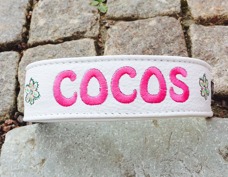Cocos-Vitt skinn med cerise text. Halsbandets bredd 4 cm. Välj variant, storlek & symboler nedan.