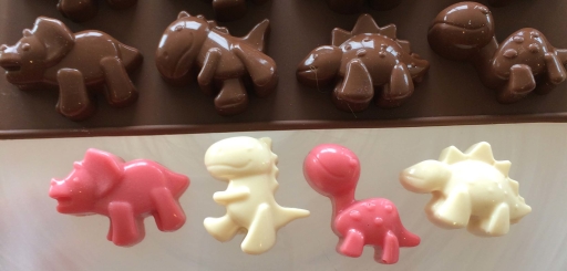 Dinosaurier av choklad, färga choklad, chokladdinos, chokladpraliner, praliner Dinosaurier av choklad, färga choklad, chokladdinos, chokladpraliner, praliner