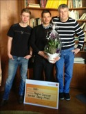 Magnus Svensson fick mottaga pris-check och blommor av Sten-Olof Öbergs son Mikael (t h) och barnbarnet Oscar (t v).