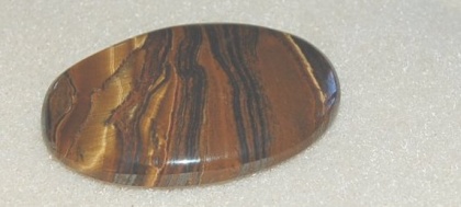 En vacker sten, Tigeröga slipad som cabochon, många använder stenen som amulettsten