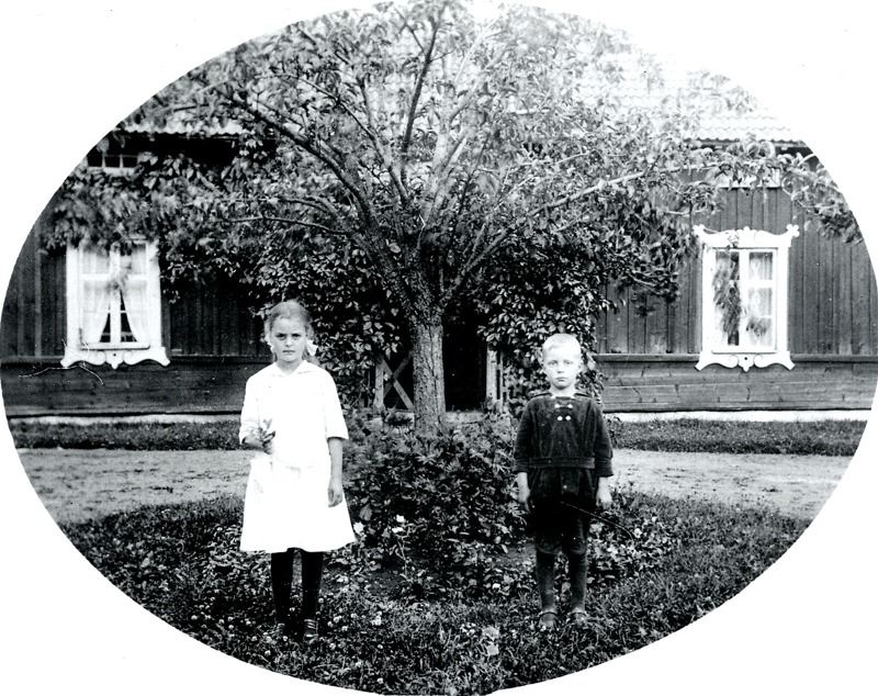 G. 9 Greta och Harald Persson framför barndomshemmet Simmesgården omkring 1920. Huset kan vara det som utflyttades från Klostrets by efter laga skiftet 1853. Insatt av Kent Friman, 2014-03-05.