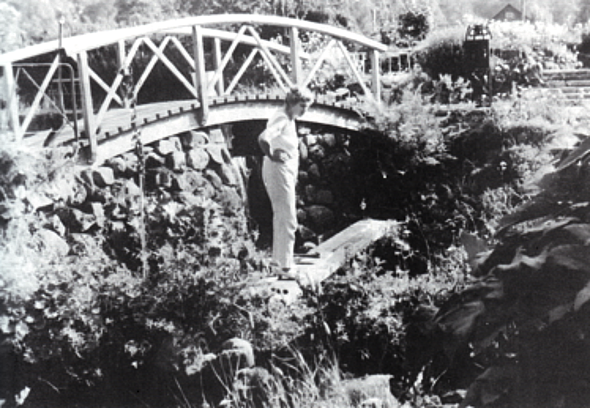 Agda Österberg år 1963 i kvarnfåran nära grunden till den gamla kvarnen som blivit simbassäng. Foto Kerstin Persson. Bild från Varnhems- bygden 1990.