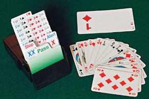 Till vänster: en budlåda för kontraktsbridge. Till höger: En spelares hand av kort (fransk kortlek). Bortom detta ligger budet på ♦, som spelaren skulle kunna lägga med hjälp av kort från budlådan. Till vänster: en budlåda för kontraktsbridge. Till höger: En spelares hand av kort (fransk kortlek). Bortom detta ligger budet på ♦, som spelaren skulle kunna lägga med hjälp av kort från budlådan.