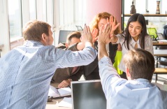 Bilden visar en arbetsgrupp som gör high five Bilden visar en arbetsgrupp som gör high five
