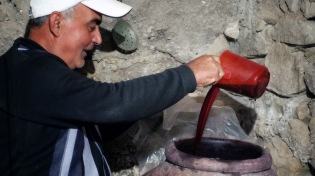 En mer än 6000 år gammal tradition - en armenisk man häller upp lagrat vin från sin källare i staden Areni. Foto: Richard Holmgren
