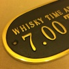 Mässingsskylt: Whisky time aboard daily: 7.00 to 6.59