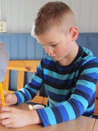 Simon,7.5 år och han koncentrerar sig på att måla påskägg.