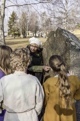 Lena Holmer, initiativtagare till Vikingamulle, visar barnen hur man läser runskrift. Foto: Peter Ullberg. Lena Holmer, initiativtagare till Vikingamulle, visar barnen hur man läser runskrift. Foto: Peter Ullberg.