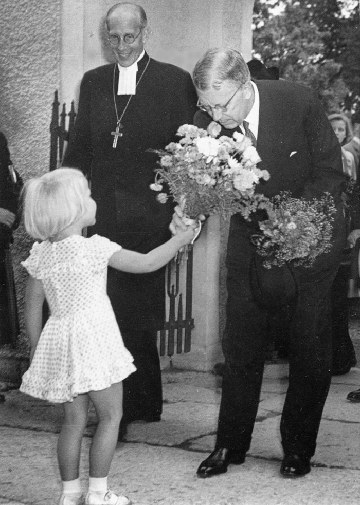 D. 17 (4) Lilla fröken Eva Hermansson överlämnar blommor till kung Gustaf VI Adolf i entréporten till kyrkan. Biskop Rudberg ler stort. Insatt av Kent Friman, 2014-02-27. Klicka på bilden för att se den mindre!