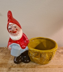 Tomte med grå vattenkanna vid kruka. Höjd 19 cm, bredd 18,5 cm. Fint skick. 95 SEK