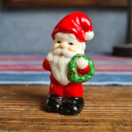 Liten tomte med grön krans. Höjd ca 6 cm. Fint skick. 20 SEK