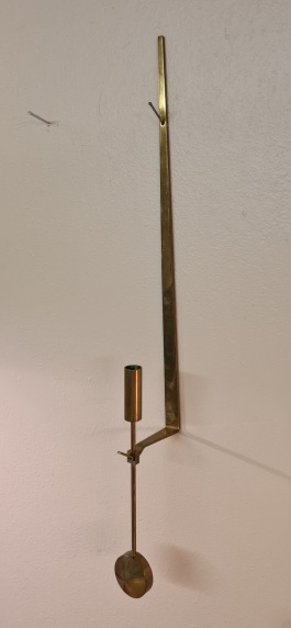 Väggljusstake Skultuna "Pendeln". Märkt Skultuna 1607 och signerad Pierre Forsell. Höjd ljushållare ca 35 cm, höjd pendel ca 20,5 cm. Fint skick, utan ljusmanschett. 450 SEK