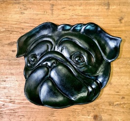 Liten väggtavla (saknar upphängningsanordning men misstänker att den är menad som tavla) som också kan användas som fat. Bredd 18 cm, höjd 14,5 cm. Osäker på material. Fint skick. 45 SEK