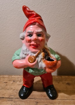 Stor stående piprökande tomte med svedd ljushållare och lagat ben. Höjd 23,5 cm. 95 SEK