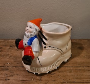 Tomte sittande på sko. Höjd 9,5 cm, längd 12 cm. Fint skick.  65 SEK