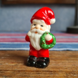 Liten tomte med grön krans. Höjd ca 6 cm. Fint skick. 20 SEK