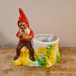 Piprökande tomte vid gulgrön stubbe. Höjd 15,5 cm. Fint skick. 150 SEK