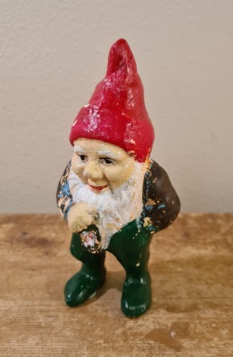 Stående tomte med lykta. Höjd 14,5 cm. Färgen flagad på tröja och luva men i övrigt hel. Någon har skrivit 1903 under ena foten. 65 SEK