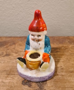 Liten sittande tomte med ljushållare (2). Höjd 7 cm. Lite färgskav på några ställen, annars fint skick. Import. 50 SEK/st
