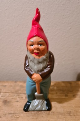 Stående tomte med spade. Brun tröja och blå byxor. Höjd 15,5 cm. Gott skick. 75 SEK