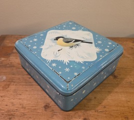 Fyrkantig blå burk med snöflingor och fågelmotiv. Mått 22x22 cm, höjd 8,5 cm. Lite skav på locket, annars gott skick. 75 SEK