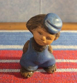 Liten figurin med blå hatt och byxor, Tilgmans (märkning under foten). Höjd ca 8 cm. Fint skick. 45 SEK
