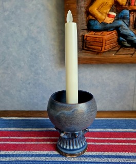 Blå klotformad ljusstake på fot, Irma Yourstone. Höjd ca11,5 cm, diam. upptill 8 cm. Ett par mininagg/skav längs foten, annars fint skick. 65 SEK