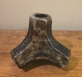 Trefotad ljusstake i okänt material.  Signerad G.H i botten. Höjd 9 cm. Fint skick. 50 SEK