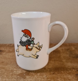 Mugg med motiv av tomte på gris. Rolf Bergh. Höjd 11 cm. Fint skick. 65 SEK
