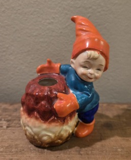 Leende tomtepojke vid kotte (ljushållare). Höjd ca 12 cm. Fint skick. 65 SEK