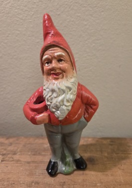 Stående tomte med grå byxor och ljushållare. Höjd ca 16 cm. Fint skick. 100 SEK