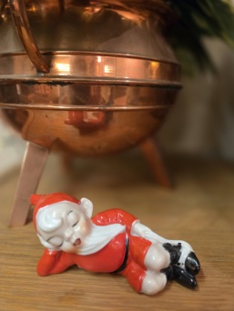 Sovande tomtenisse. Längd 11 cm. Färgen lite sliten på foten, annars gott  skick. 45 SEK