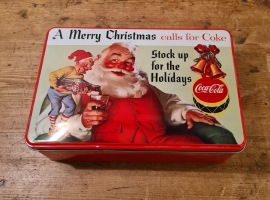 Rektangulär burk - "A merry Christmas calls for Coke - Stock up for the holidays". Längd 20 cm, bredd 13 cm, höjd 6,5 cm. Fint skick. Nyare. 40 SEK