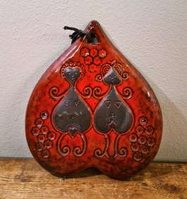 Hjärtformad keramiktavla med rödbrunt motiv. Osignerad. Höjd 23 cm, bredd 20 cm. Fint skick. 75 SEK
