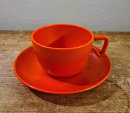 Orange plastkopp med fat. Diam. fat 13,5 cm. Höjd kopp 6 cm. Märkt Made in Finland, "Sarvis". Fint skick. 50 SEK