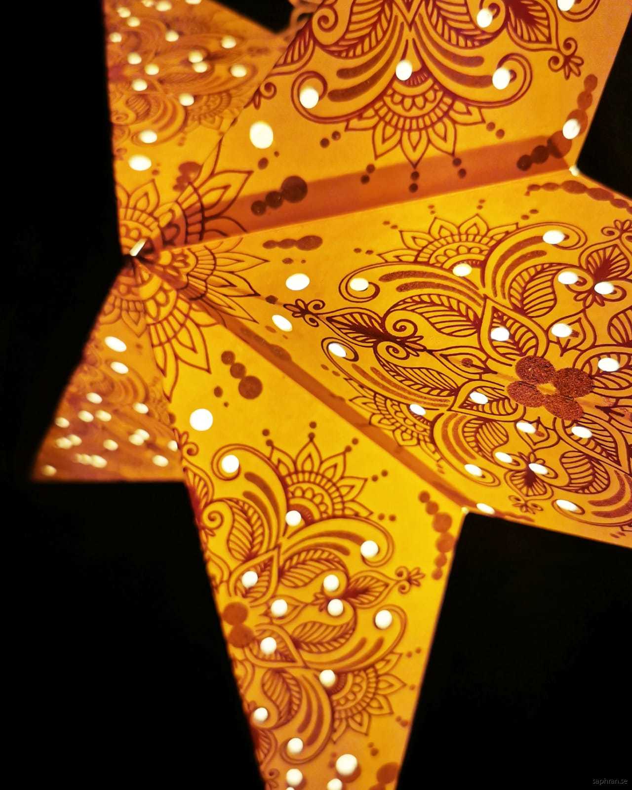 Färgglad, guldglittrig julstjärna i papper med lila detaljer