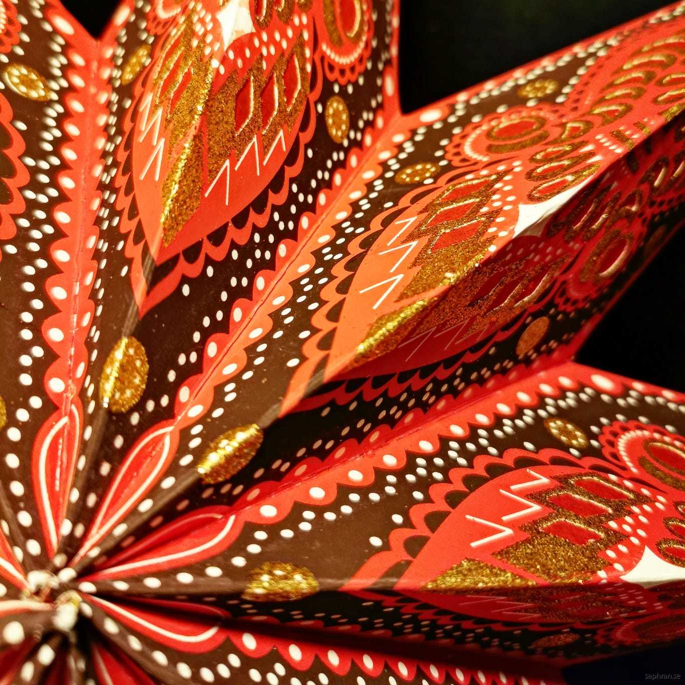 En unik, vacker, dekorativ, mönstrad och färgglad julstjärna i kitschig, orientalisk stil importerad från Indien
