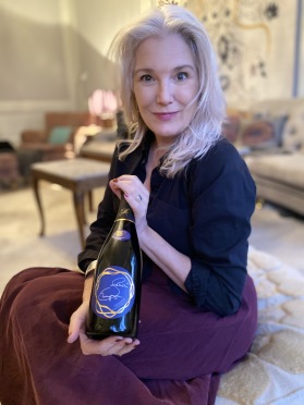 Charlotte med den första flaskan Skellefteå Champagne i hemmet i Stockholm. Champagnen har blivit utvald till den franska  vinguiden Le Guide  Hachette des Vins 2024.