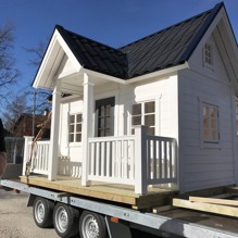 Lekstuga Brunnsgården X-Large (32 900 kr) med tillvalen Dörr med fönster (500 kr), Mellanpaketet innehållande takpanneplåt, blomlådor, fågelholk och öppningsbart fönster (7 000 kr) = 40 400 kr komplett. OBS: Kunden har specialbeställt slutmålning.