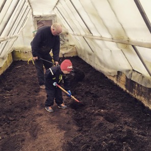 Ian hjälper morfar förbereda växthuset för tomatodling.