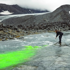 The water flow is measured using a fluorescein tracer dye called uranine, and that is why the water is green. Photo: Karuna Sah.