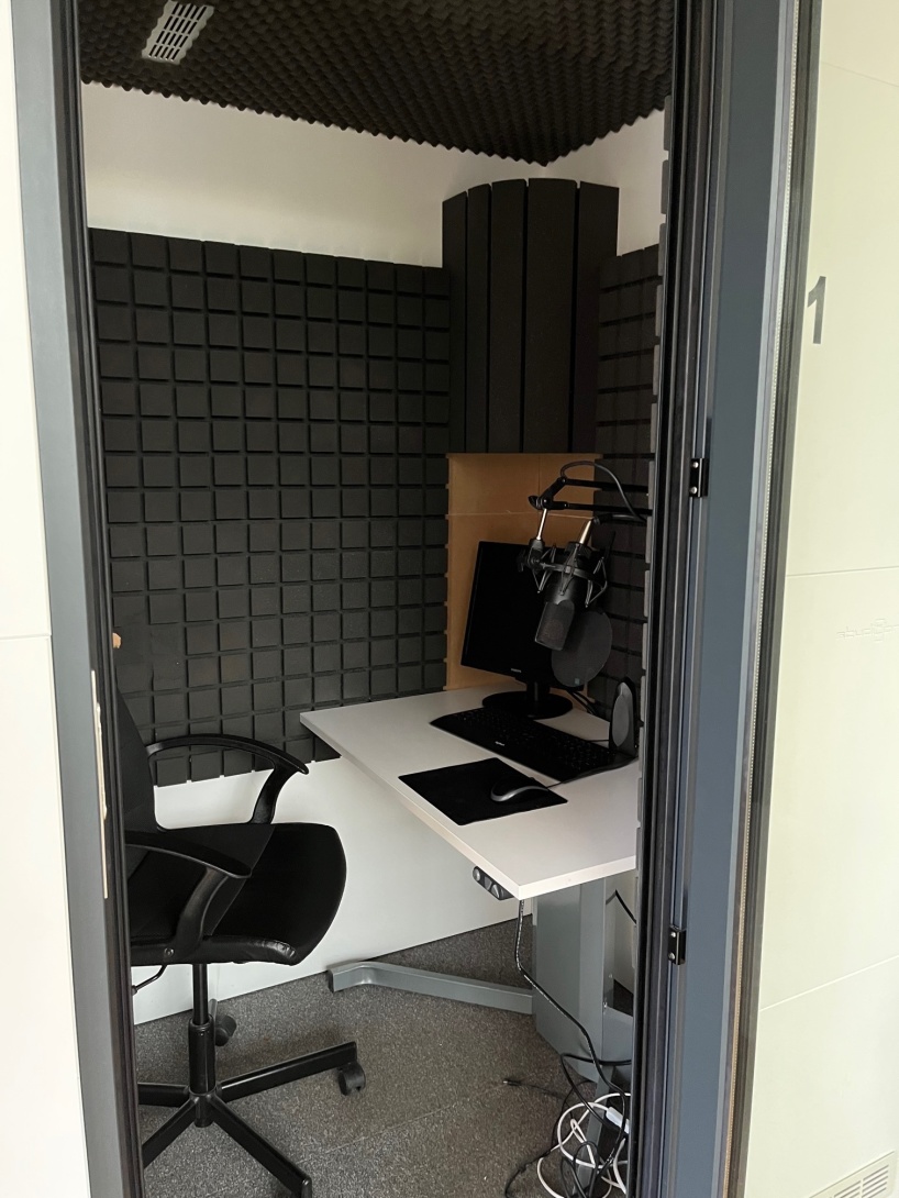 Syntolkning: Insidan av en ljudstudio klädd med ljudplattor, ett bord med en skärm, tangentbord och mikrofon. Vid bordet finns en kontorsstol.