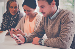 Tre studentkonsulter som testar den responsiva designen på mobilerna. Tre studentkonsulter som testar den responsiva designen på mobilerna.