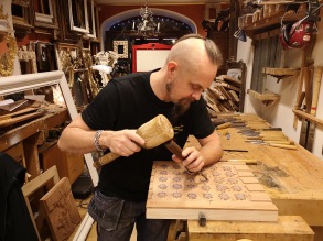 Träbildhuggare Christer i färd med att skära ut tryckblockets mönster