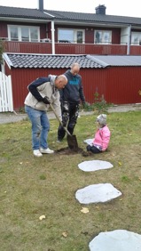James, Mats och Tuva jobbar med att lägga ut fina stenar upp till lekstugan.