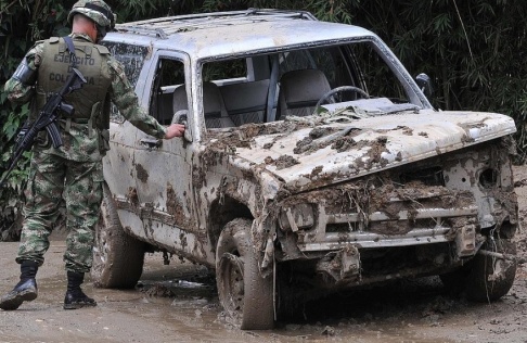 Luis Benavides/AP/TT En soldat undersöker en bil som skadats i ett jordskred i Colombia 2011. Luis Benavides/AP/TT En soldat undersöker en bil som skadats i ett jordskred i Colombia 2011.